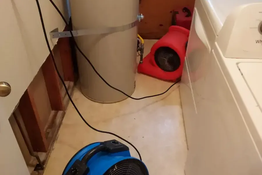 A laundry room wall opened behind the washer with air movers drying the cavity