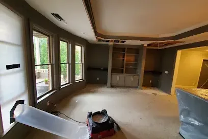 An air mover ducted into an opened wall cavity during structural drying